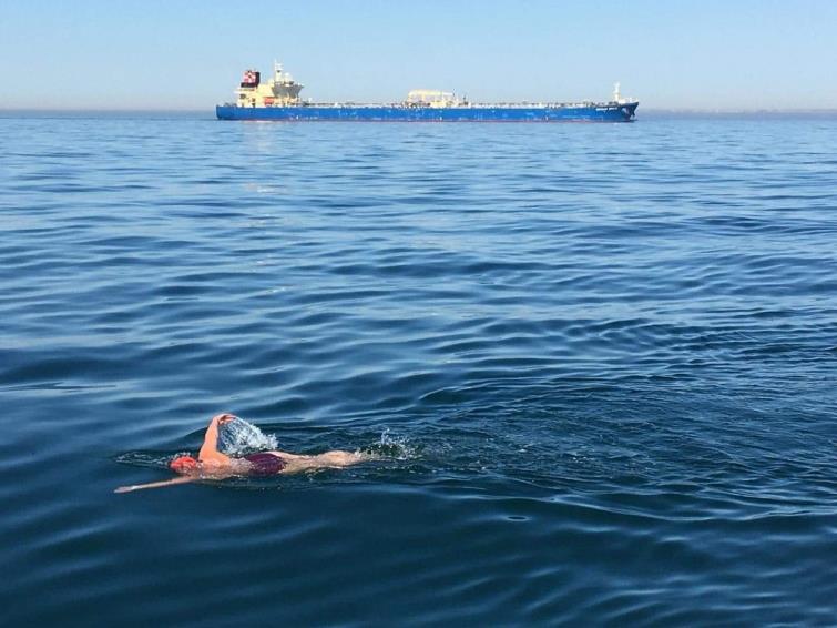 Sarah swims as a ship comes near